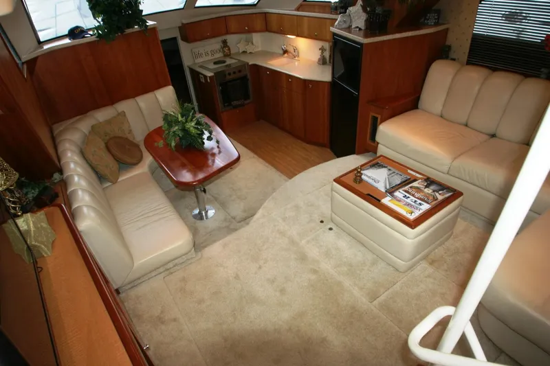 Slide: The Image of Interior of a 2000 Silverton 392 Motor Yacht with beige seating and wooden accents. - 46