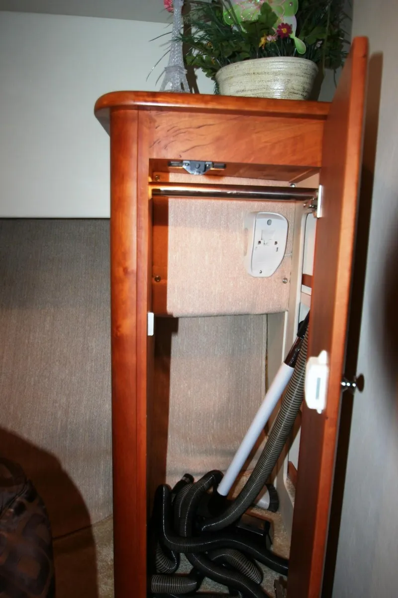 Slide: The Image of Cabinet interior of a 2000 Silverton 392 Motor Yacht with hoses and a plant on top. - 9