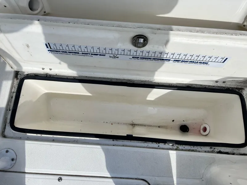 Slide: The Image of Open storage compartment on 2014 Striper 220 Center Console boat with measurement guide. - 15