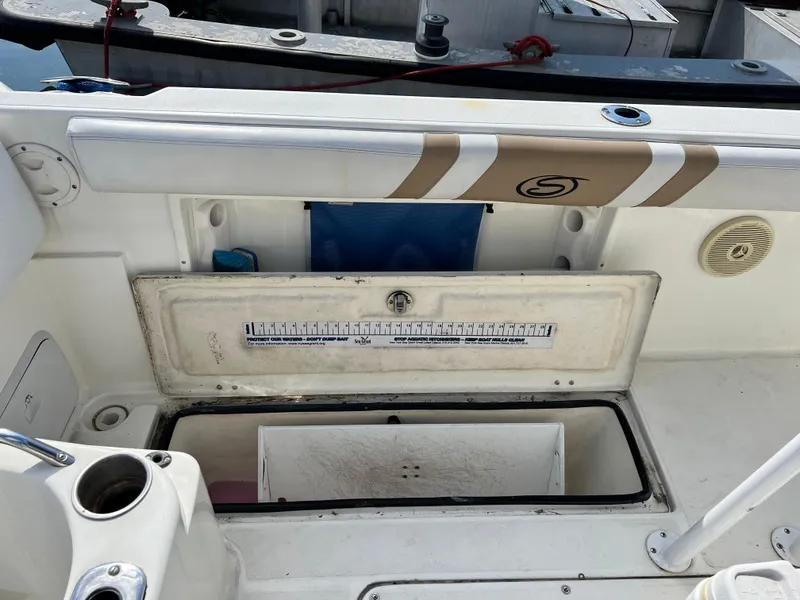 Slide: The Image of 2014 Striper 220 Center Console boat interior with storage compartment open. - 17