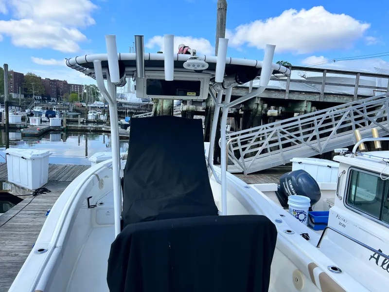 Slide: The Image of 2014 Striper 220 Center Console boat docked at marina with clear blue sky. - 2