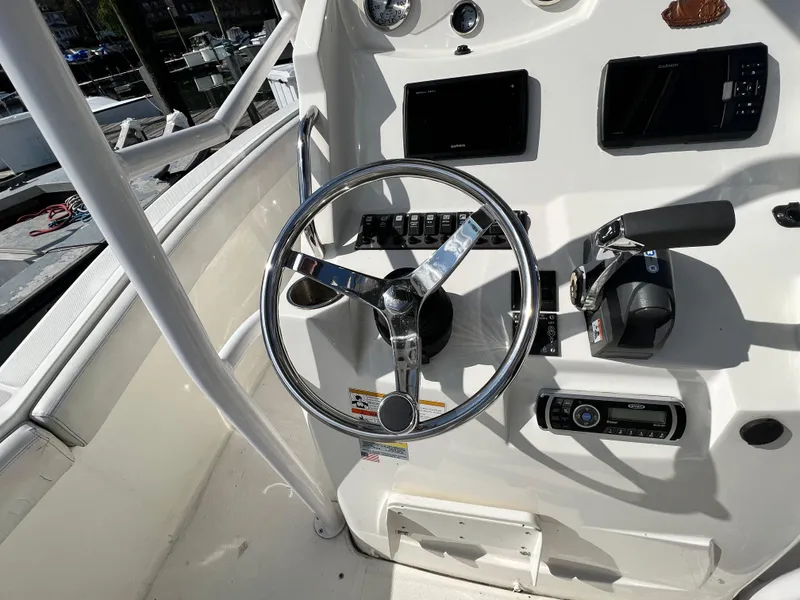 Slide: The Image of 2014 Striper 220 Center Console boat dashboard with steering wheel and controls. - 21