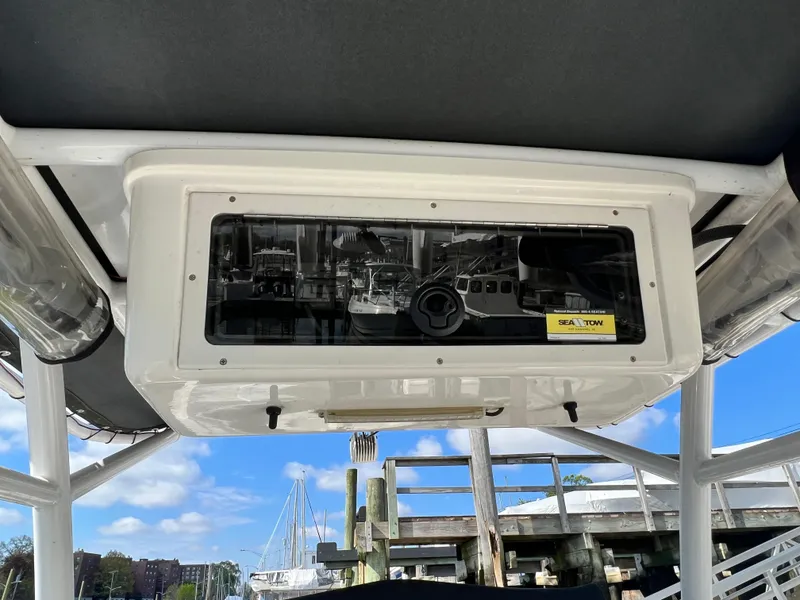 Slide: The Image of 2014 Striper 220 Center Console boat with overhead storage and Sea Tow sticker, docked at marina. - 26
