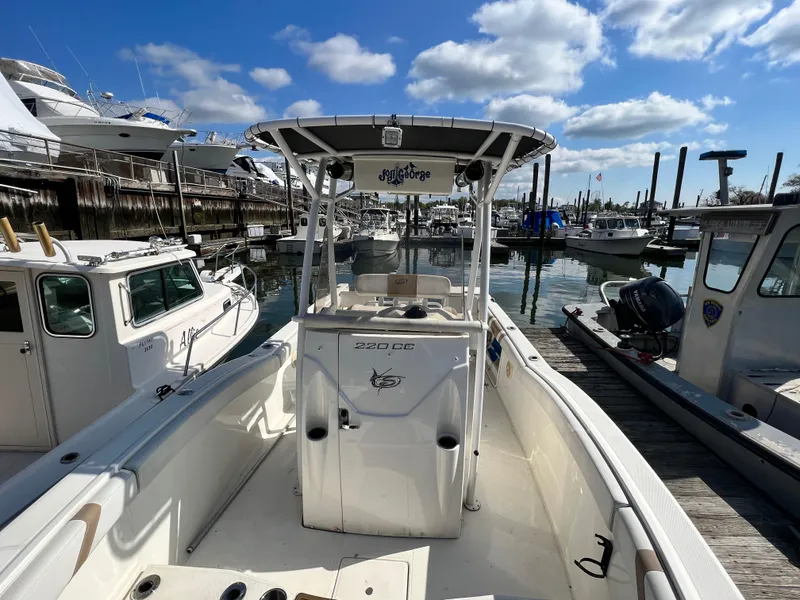 Slide: The Image of 2014 Striper 220 Center Console boat docked at marina under blue sky. - 39