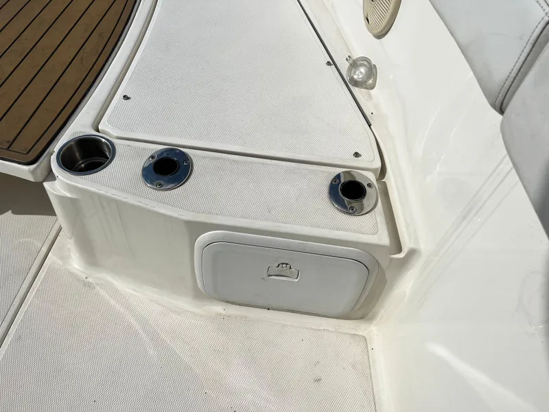 Slide: The Image of 2014 Striper 220 Center Console boat interior with cup holders and storage compartment. - 47