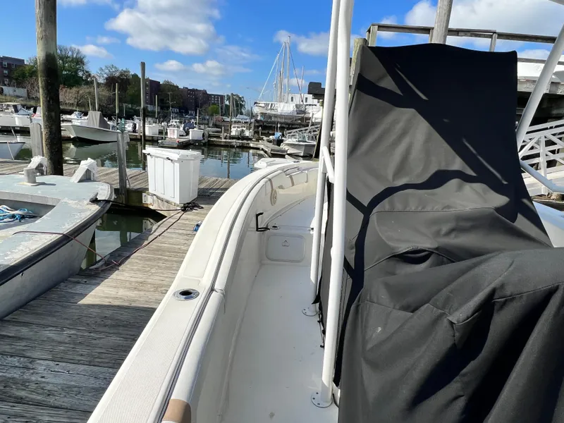 Slide: The Image of 2014 Striper 220 Center Console boat docked at a marina under a clear blue sky. - 5
