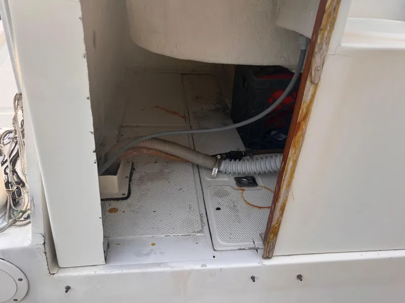 Slide: The Image of Interior view of a 1988 Canyon Bay 40 boat showing storage compartment and hoses. - 10