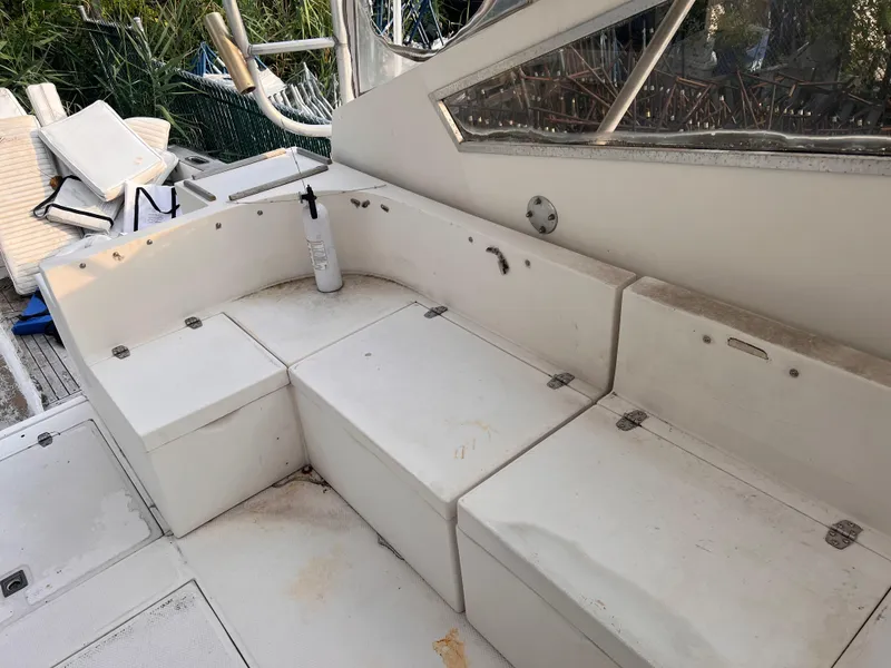 Slide: The Image of 1988 Canyon Bay 40 boat seating area with storage compartments and outdoor cushions. - 15
