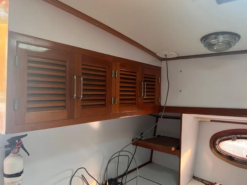 Slide: The Image of Interior of 1988 Canyon Bay 40 boat with wooden cabinets and porthole. - 17