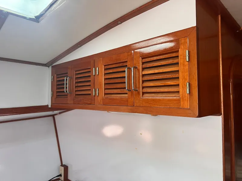 Slide: The Image of Wooden cabinet with louvered doors inside a 1988 Canyon Bay 40 boat. - 18