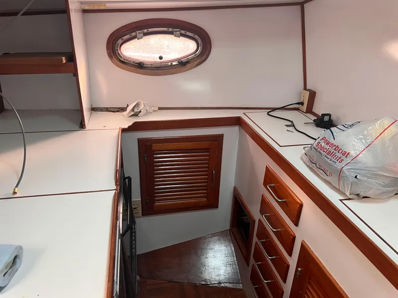 Slide: The Image of Interior of 1988 Canyon Bay 40 boat with wooden cabinets and porthole window. - 19