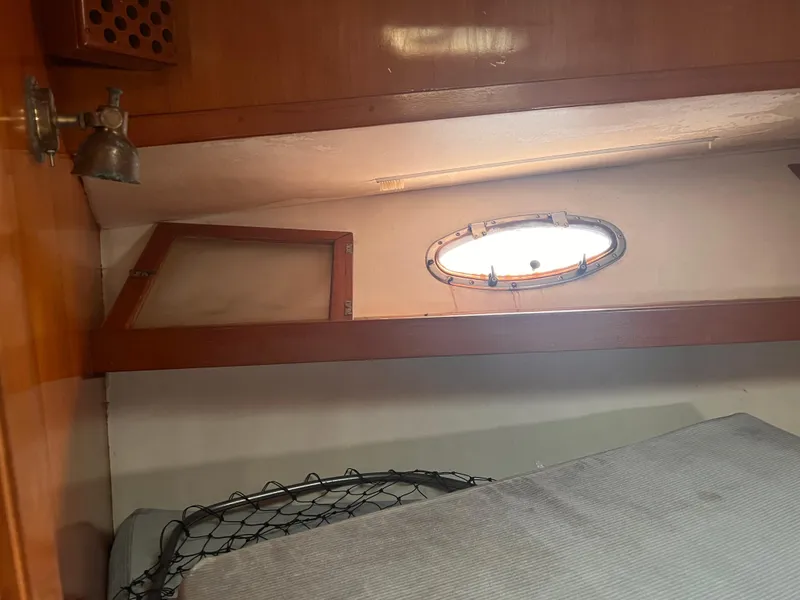 Slide: The Image of Interior cabin of 1988 Canyon Bay 40 boat with porthole and wooden accents. - 26