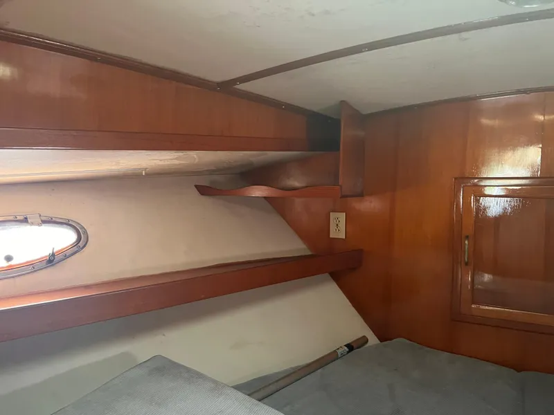 Slide: The Image of Interior cabin of 1988 Canyon Bay 40 boat with wooden shelves and porthole. - 27