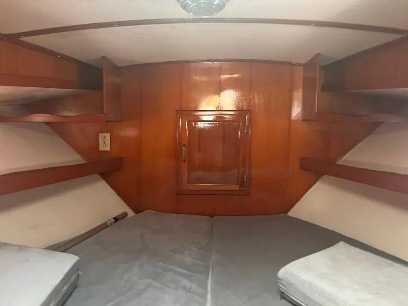 Slide: The Image of Interior cabin of 1988 Canyon Bay 40 boat with wooden paneling and cushioned seating. - 28