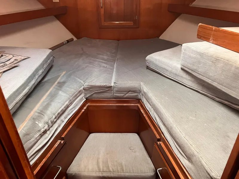 Slide: The Image of 1988 Canyon Bay 40 cabin interior with gray cushions and wooden accents. - 30