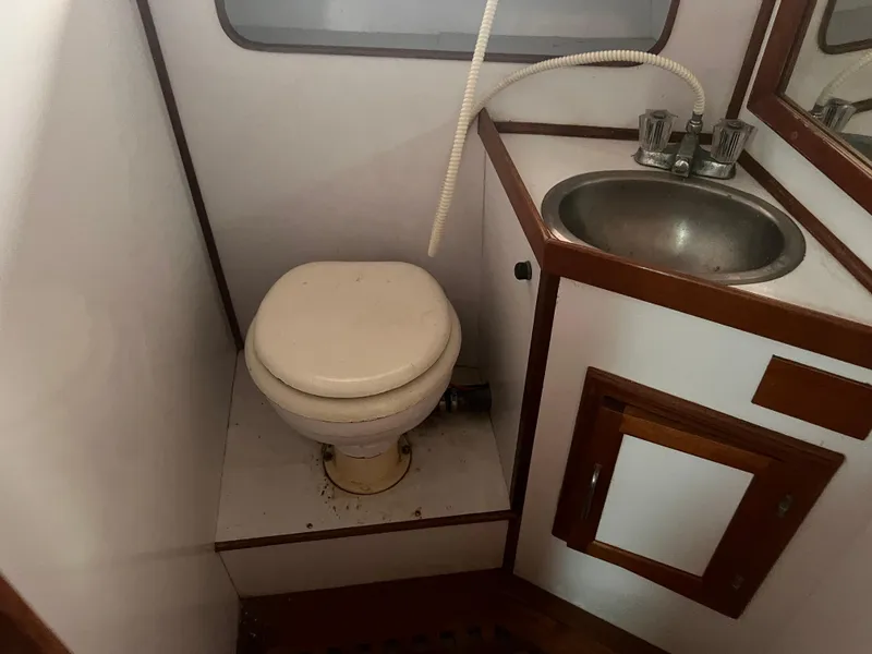 Slide: The Image of 1988 Canyon Bay 40 boat bathroom with toilet and sink. - 31