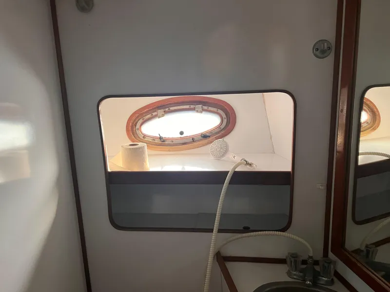 Slide: The Image of Interior of 1988 Canyon Bay 40 boat bathroom with porthole and sink. - 32