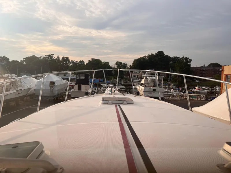 Slide: The Image of Bow view of 1988 Canyon Bay 40 yacht docked at marina under cloudy sky. - 4