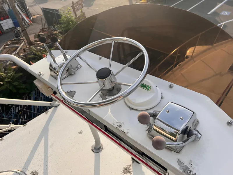 Slide: The Image of Helm of 1988 Canyon Bay 40 boat with steering wheel and controls. - 43