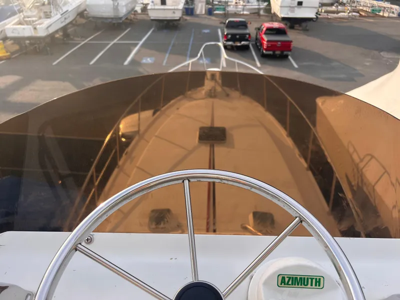 Slide: The Image of Steering wheel view from 1988 Canyon Bay 40 boat, docked with other vessels in background. - 44