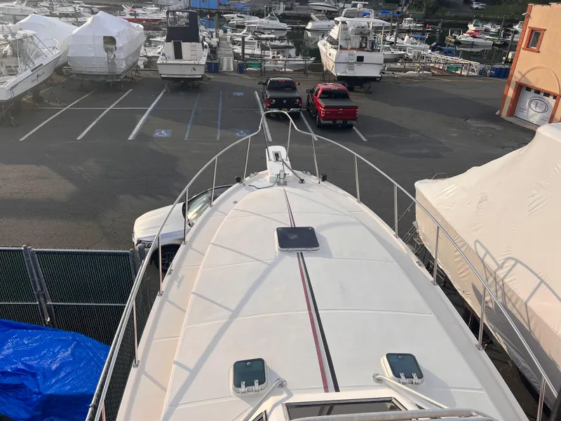 Slide: The Image of Canyon Bay 40 boat from 1988 in a marina with parked vehicles. - 45