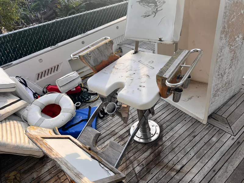 Slide: The Image of Fishing chair on 1988 Canyon Bay 40 boat with scattered equipment and weathered deck. - 7