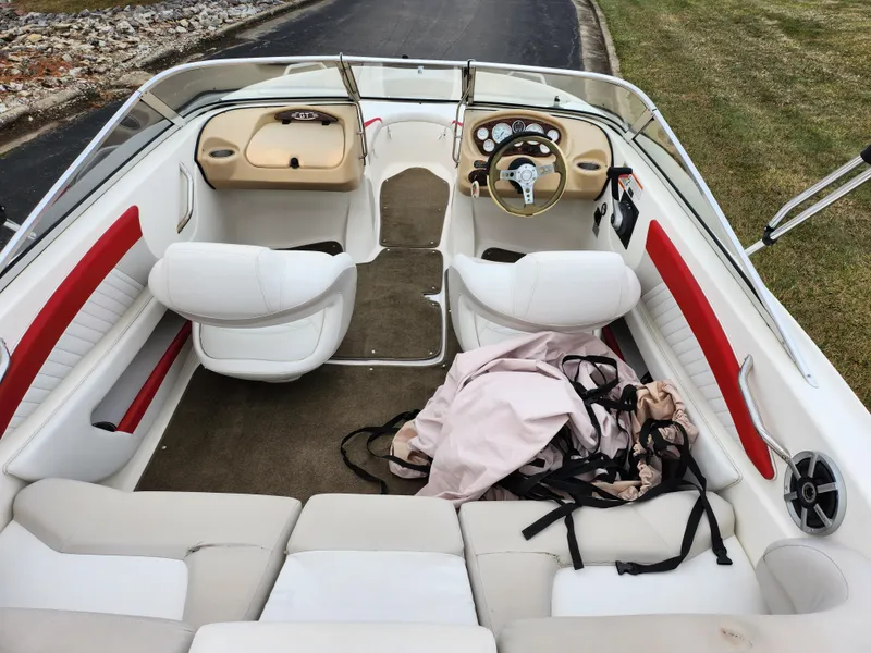 Slide: The Image of 2008 Glastron GT 205 boat interior with white and red seating, steering wheel, and dashboard. - 10