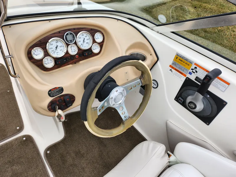 Slide: The Image of 2008 Glastron GT 205 boat dashboard with steering wheel and control panel. - 12