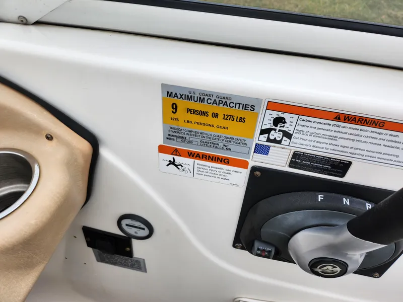 Slide: The Image of 2008 Glastron GT 205 boat capacity and warning labels near steering wheel. - 13
