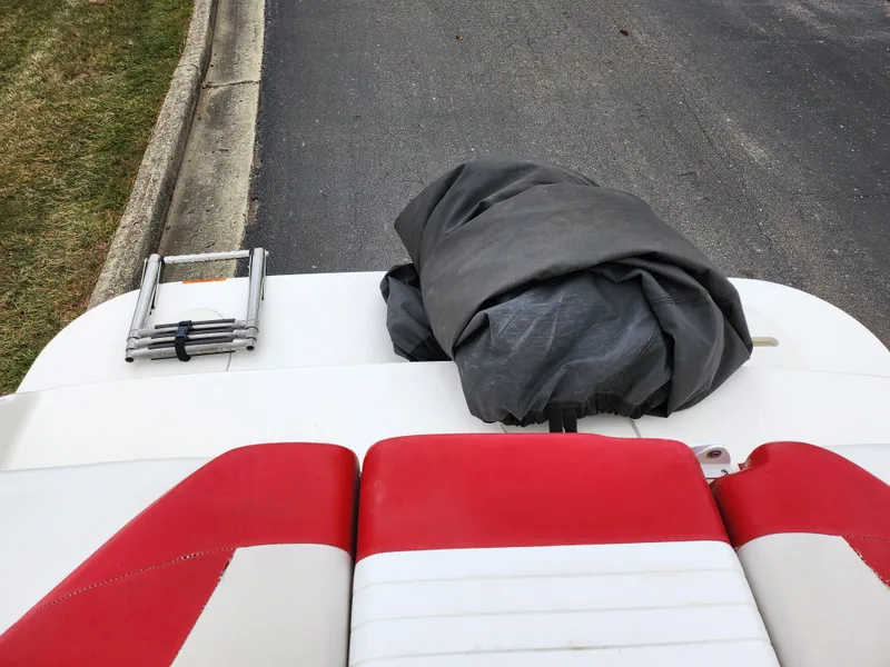 Slide: The Image of 2008 Glastron GT 205 boat rear view with red and white seats, ladder, and cover. - 24