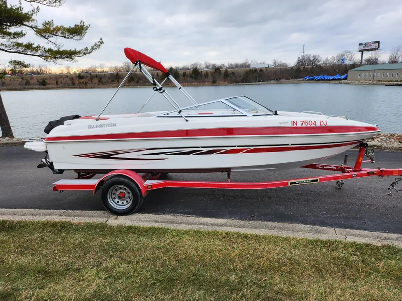 Slide: The Image of 2008 Glastron GT 205 boat on a red trailer by a lake. - 9