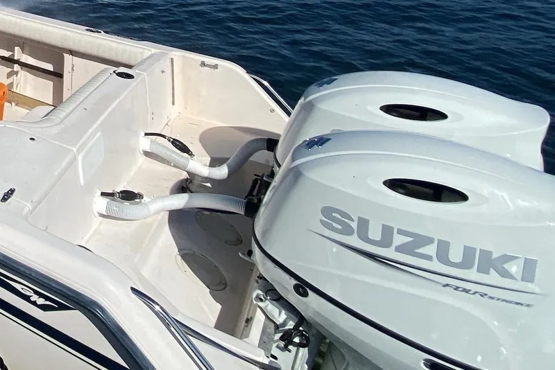 Slide: The Image of 1996 Grady-White Chase 263 boat with dual Suzuki outboard motors on the water. - 2