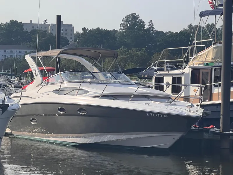 The Image of 2011 Regal 35 Express Cruiser docked at marina, surrounded by other boats. - 0