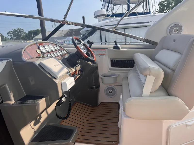 Slide: The Image of 2011 Regal 35 Express Cruiser helm with gauges, steering wheel, and cushioned seating. - 13