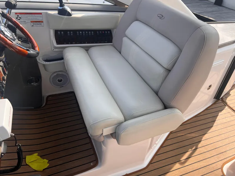 Slide: The Image of 2011 Regal 35 Express Cruiser helm seat with wood accents and control panel. - 14