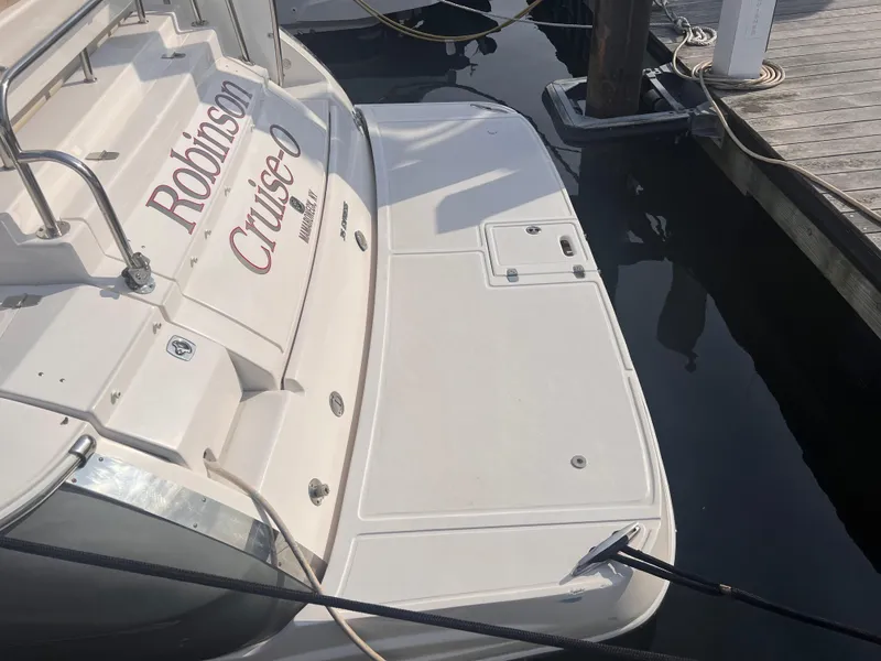 Slide: The Image of 2011 Regal 35 Express Cruiser docked, showing rear deck and water reflection. - 3