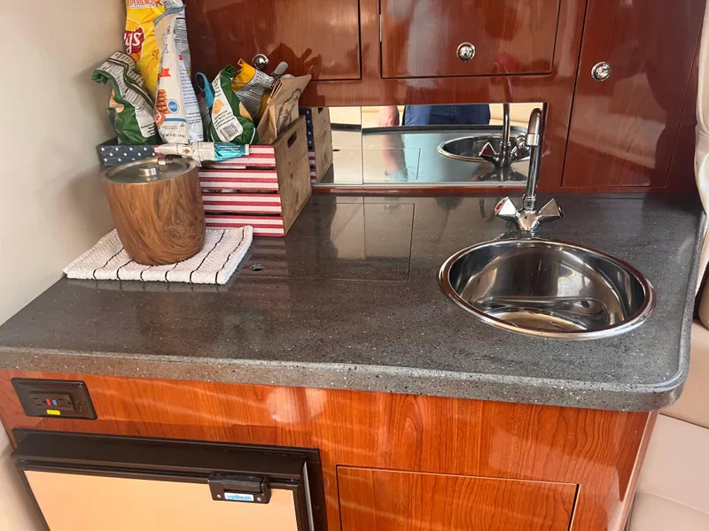 Slide: The Image of 2011 Regal 35 Express Cruiser kitchenette with sink, countertop, and storage. - 30
