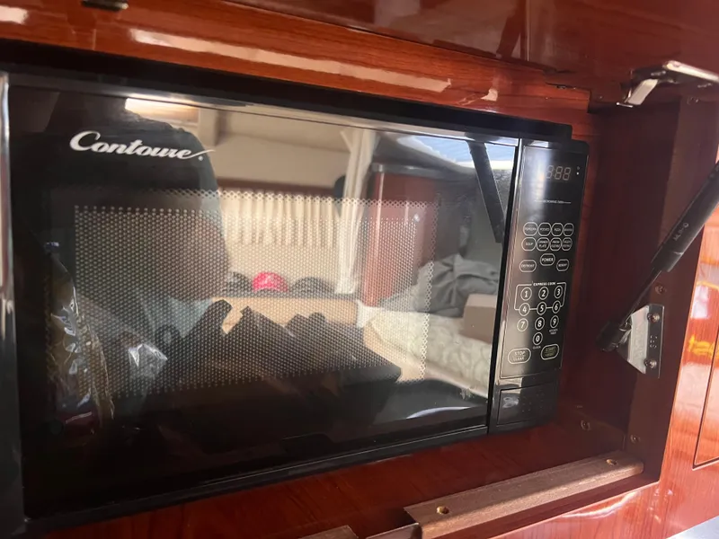 Slide: The Image of Microwave inside 2011 Regal 35 Express Cruiser with wood paneling. - 35