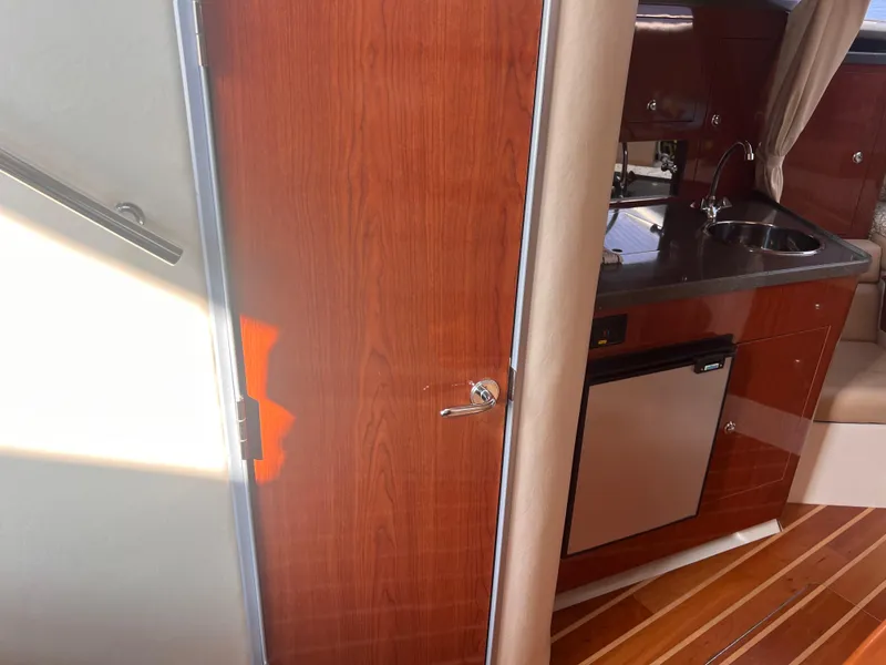 Slide: The Image of Interior of 2011 Regal 35 Express Cruiser with kitchenette and wooden cabinetry. - 36