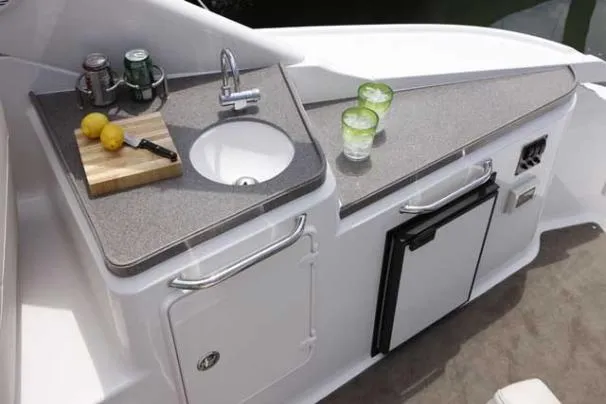 Slide: The Image of Outdoor kitchenette on 2011 Regal 35 Express Cruiser with sink, cutting board, and mini fridge. - 46