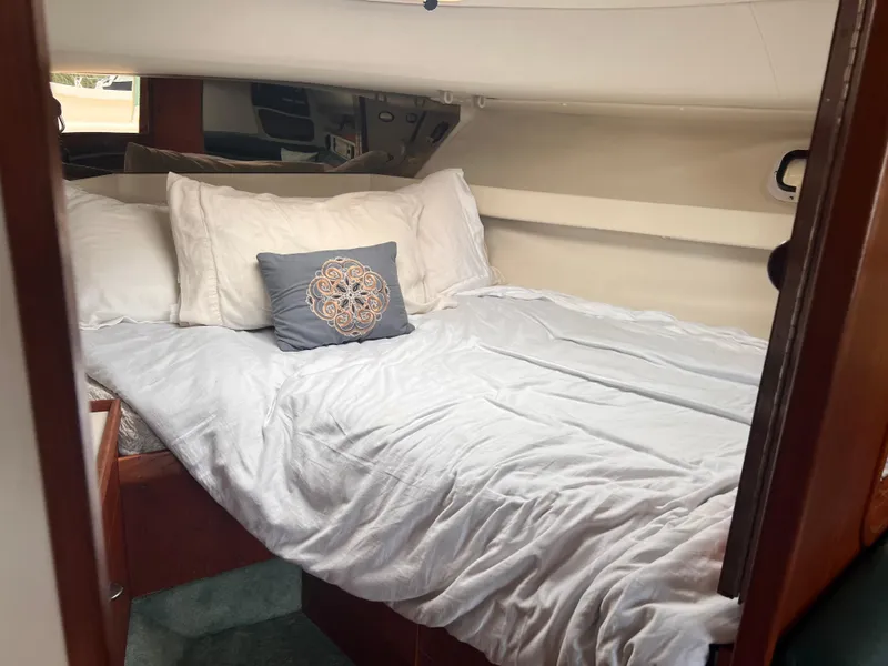 Slide: The Image of Cozy cabin interior of 1996 Pursuit 3100 Open with neatly made bed. - 13