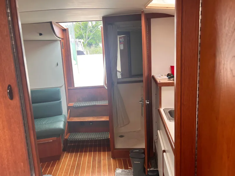 Slide: The Image of Interior of 1996 Pursuit 3100 Open boat with wood finish and compact amenities. - 16