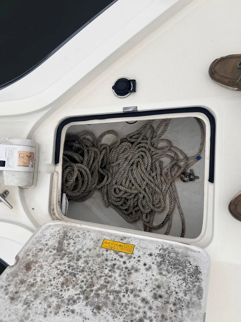 Slide: The Image of Storage compartment with ropes on a 1996 Pursuit 3100 Open boat deck. - 27