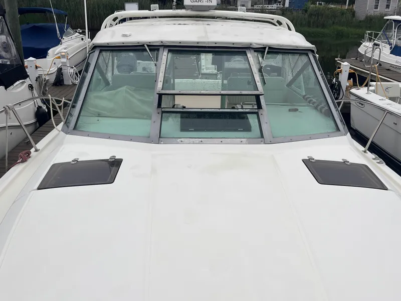 Slide: The Image of 1996 Pursuit 3100 Open boat docked, showcasing front deck and windshield. - 28