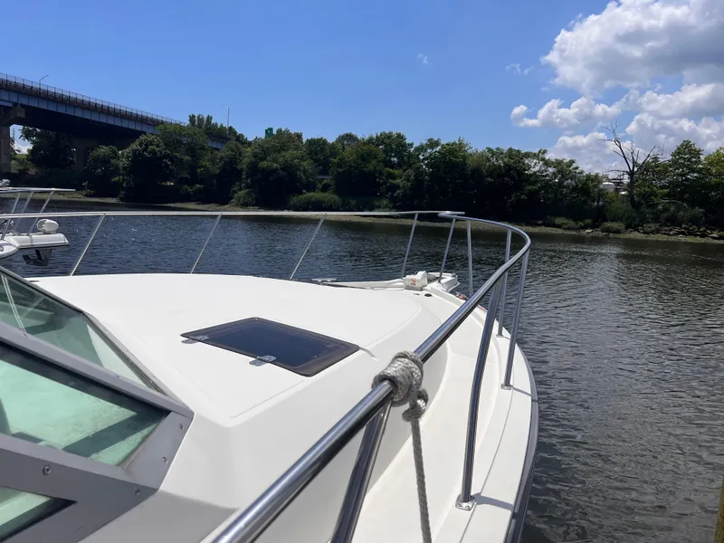 Slide: The Image of 1996 Pursuit 3100 Open boat on calm river under blue sky. - 3