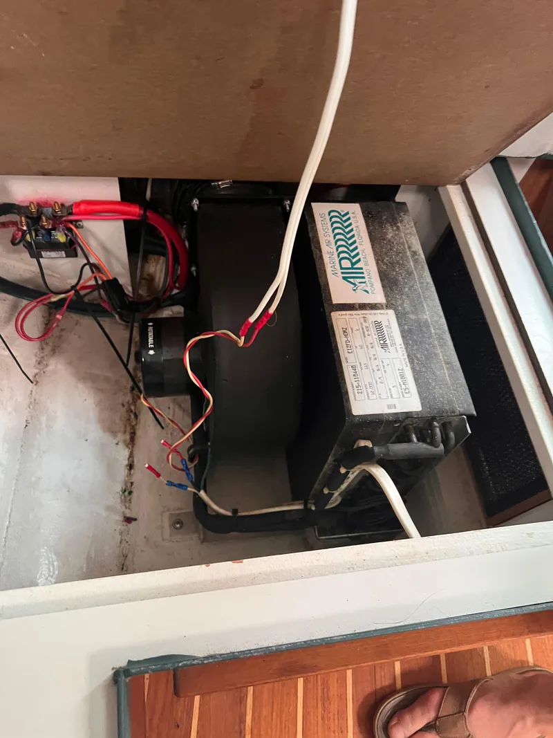 Slide: The Image of Electrical components inside a 1996 Pursuit 3100 Open boat, featuring wiring and an air conditioning unit. - 31