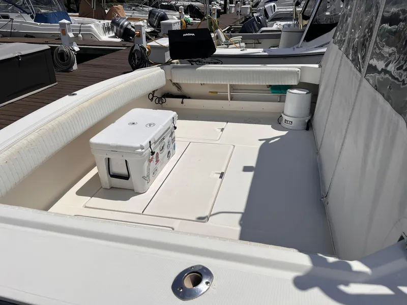 Slide: The Image of 1996 Pursuit 3100 Open boat deck with cooler and seating at marina. - 4