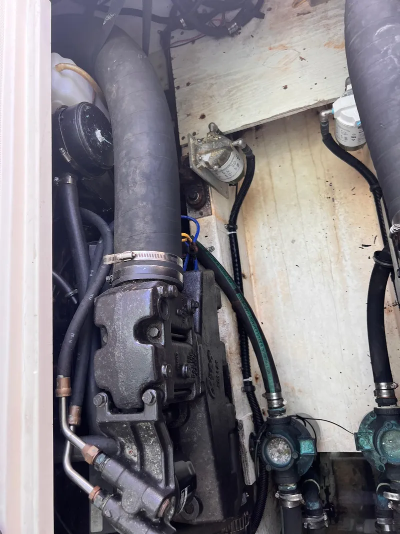 Slide: The Image of Engine compartment of a 1996 Pursuit 3100 Open boat, showing hoses and mechanical components. - 7