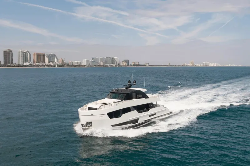 Slide: The Image of 2023 Ocean Alexander 32E yacht cruising near a coastal city skyline. - 4