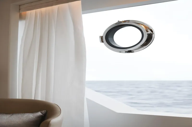 Slide: The Image of Interior view of Ocean Alexander 32E yacht, 2023 model, featuring a porthole and white curtains. - 46